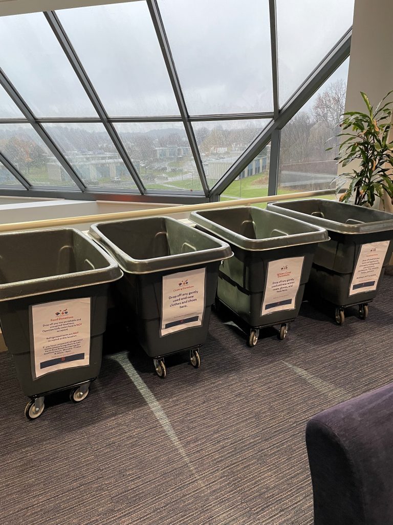 Gray bins labeled for 'Cuse Collections in the Goldstein Student Center on South Campus.