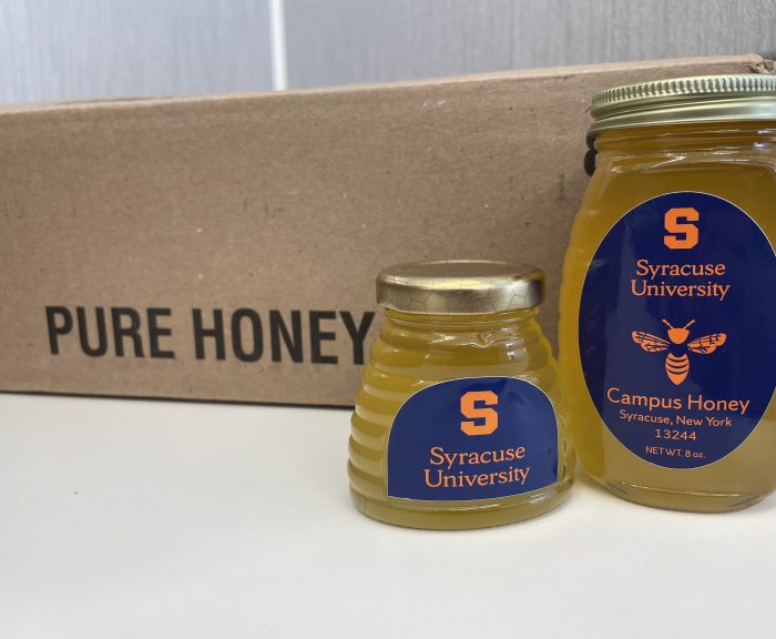 A 3 and 8 ounce jar full of honey on display with a box labeled 